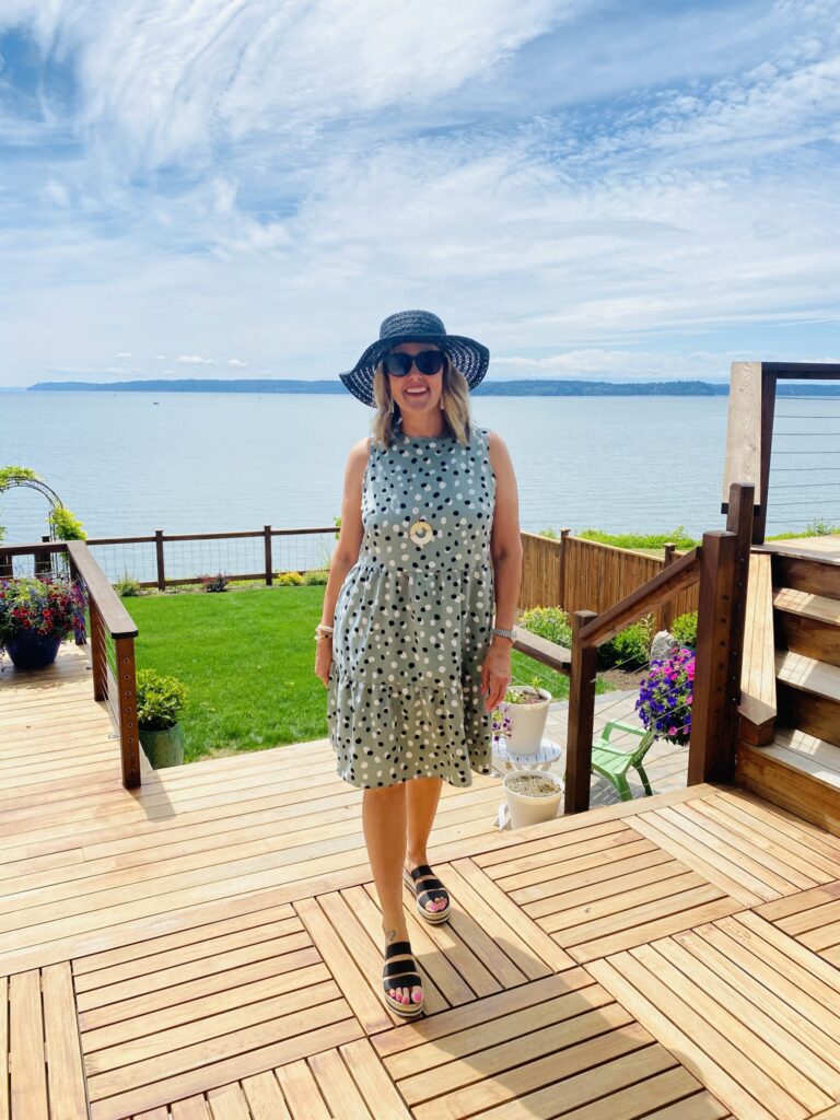 woman standing neat the lake and wearing ruffled polka dot dress for Amazon Summer Style Roundup 