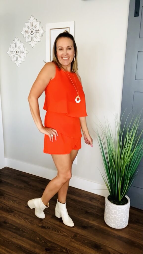 woman smiling and wearing sleeveless ruffle romper dress in red for Amazon Summer Style Roundup 
