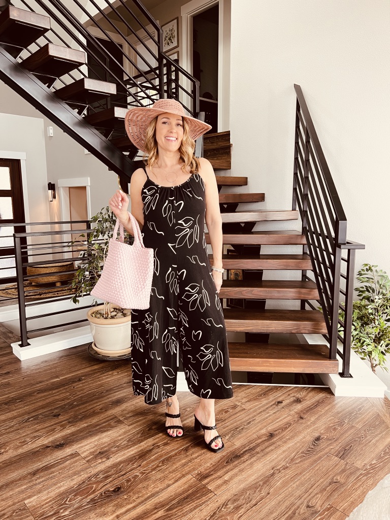 woman wearing SUMMERLAND ABSTRACT FLORAL JUMPSUIT and summer hat for resort wear