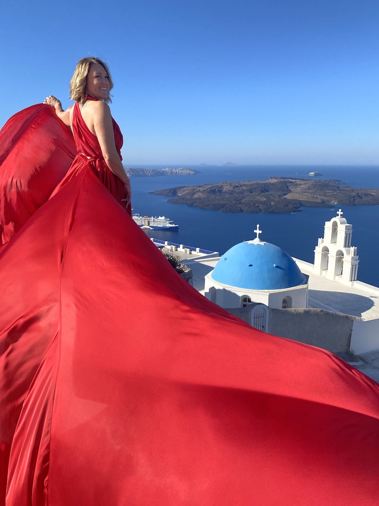 wearing a red dress in santorini greece