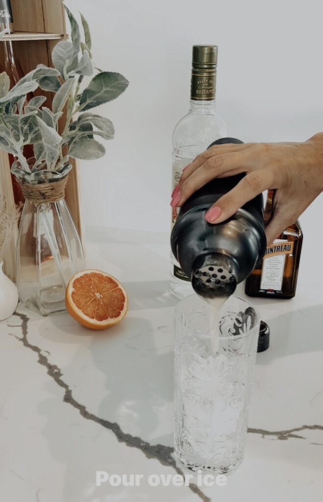 pouring Grapefruit Vodka Fizz on glass with ice